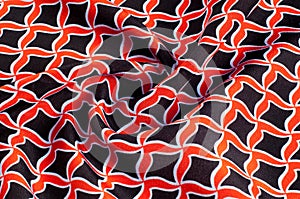 Texture, background, pattern. Fabric drawing of a diamond diamond red on a black background