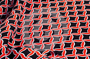 Texture, background, pattern. Fabric drawing of a diamond diamond red on a black background