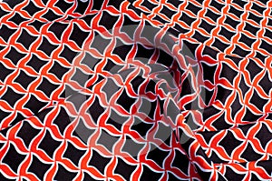 Texture, background, pattern. Fabric drawing of a diamond diamond red on a black background
