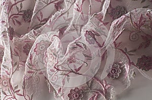 Texture, background, pattern. Pink lace decorated with flowers o