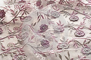 Texture, background, pattern. Pink lace decorated with flowers o