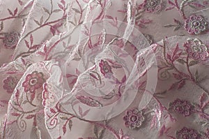 Texture, background, pattern. Pink lace decorated with flowers o