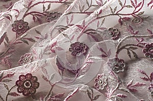 Texture, background, pattern. Pink lace decorated with flowers o