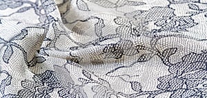 Texture, background, pattern. Silk white fabric with lace patterns. This elastic lace trim can add a delicate touch to everything