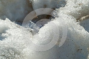 Texture, background, pattern. The spring snow melts. The beginning of a warm season, spring. Melting snow on the ground in the ci