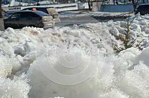 Texture, background, pattern. The spring snow melts. The beginning of a warm season, spring. Melting snow on the ground in the ci