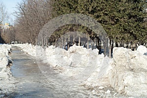 Texture, background, pattern. The spring snow melts. The beginning of a warm season, spring. Melting snow on the ground in the ci