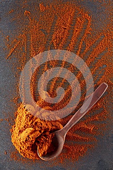 Texture background. Red chilli pepper powder mixed with wooden spoon. Top view