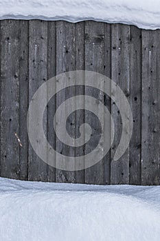 Texture, background. Wooden fence covered with snow from above and below. Wooden fence in the winter.