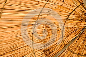 Texture of beautiful straw natural sun umbrellas from hay with patterns in a tropical desert resort, rest. The background