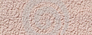Texture of beige fluffy woolen textile background from soft fleecy material, macro. Structure of brown fabric