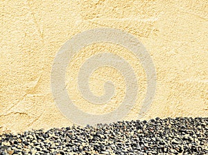 Texture of beige sand plaster with sea pebbles, concept of summer background, vacation and recreation