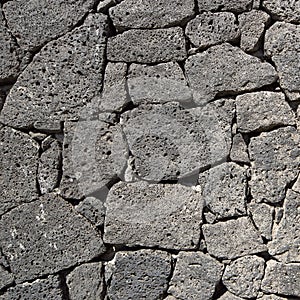 Texture of the black volcanic rock wall
