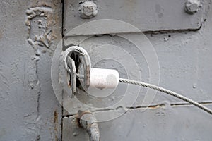 Texture of a blue iron metal door with a lock made from improvised handicraft metal wire rope. The background