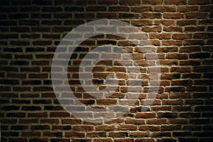 The texture of a brick wall with a light spot. Abstract.