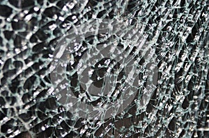 Texture of broken glass on dark background. Closeup