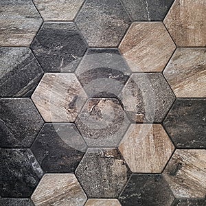 The texture of the ceramic tiles in the form of a hexagon made of brown natural stone. Concept texture, background