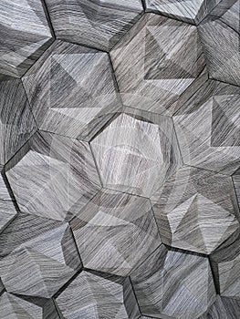 The texture of the ceramic tiles in the form of a hexagon made of natural stone of gray color with convex surfaces of a triangular