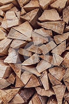 Texture of chopped firewood stacked one on top of another in a woodshed