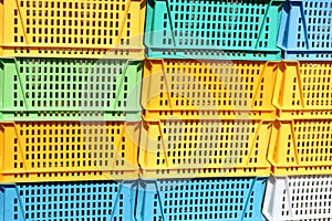 Texture from colored plastic colored yellow blue green rectangular boxes with holes for goods, bottles