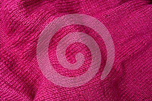 The texture of cotton folded knitted fabric, bright crumpled pink woolen knitwear textile background