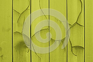 Texture of cracked yellowish paint, metal plates painted yellow with spots of paint, siding with cracks