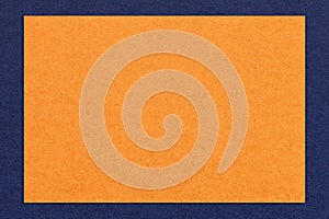 Texture of craft orange color paper background with navy blue border, macro. Structure of vintage dense kraft cardboard