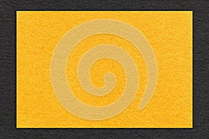 Texture of craft yellow paper background with black border, macro. Structure of cardboard with empty orange frame