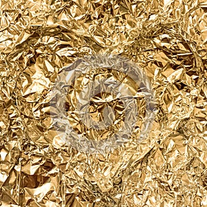 Texture of crumpled golden foil. Shiny festive background. Metallized paper.