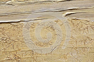 The texture of crumpled paper, and gold paint relief