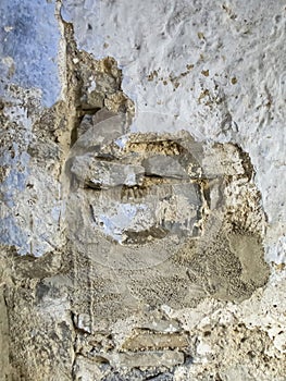 texture of a deteriorated old wall, with a partially repaired spalling