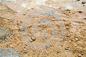 Texture of a dirty bad dirt road dirt road with puddles and clay drying mud with cracks and ruts. Off-road. The background