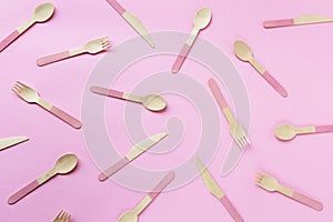 Texture of disposable bamboo spoons, forks and knives on pink background. Zero waste concept. Top view, flat lay