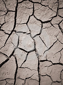 Texture of dry cracked earth. The desert background. The global shortage of water. Deep cracks in brown land as symbol of hot