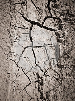 Texture of dry cracked earth. The desert background. The global shortage of water. Deep cracks in brown land as symbol of hot