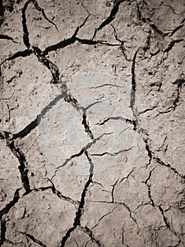 Texture of dry cracked earth. The desert background. The global shortage of water. Deep cracks in brown land as symbol of hot