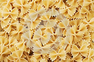 Texture of dry Italian pasta macaroni bows farfalle. Close up. Background carbohydrates food