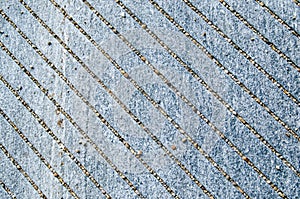 Texture of external stone floor, granite stone slab with engraved cutter anti-slip oblique lines, for pedestrian passage.