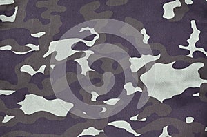 Texture of fabric with a camouflage painted in colors of the marsh. Army background image. Textile pattern of military camouflage