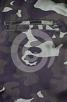 Texture of fabric with a camouflage painted in colors of the marsh with pocket. Army background image. Textile pattern of militar