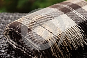 The texture of the fabric of a warm woolen brown beige checkered plaid with fringes. photo