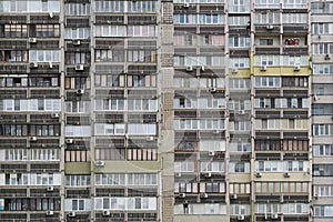 Texture of the facade of a multi-storey residential building with windows and balconies. Old Soviet design.