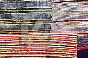 Texture of four various carpets handmade on hand-loom with colorful vertical lines