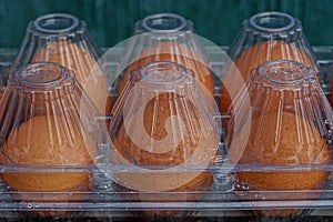 Texture of fresh brown eggs in transparent closed plastic packaging