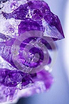 Texture of gemstone lilac Amethyst closeup as a part of cluster geode filled with rock Quartz crystals.