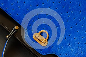 Texture of genuine leather close-up with embossed under the skin of Ostrich, gold lock, fashion blue color. Background