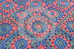 Texture of granny squares crochet afghan in red, blue and green.