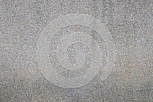 Texture of gray concrete wall with small pebble stones as background