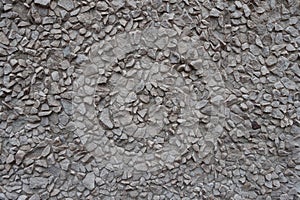 Texture of gray gravel pebble dash on the wall