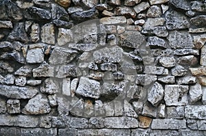 Texture of gray rough granite stone wall